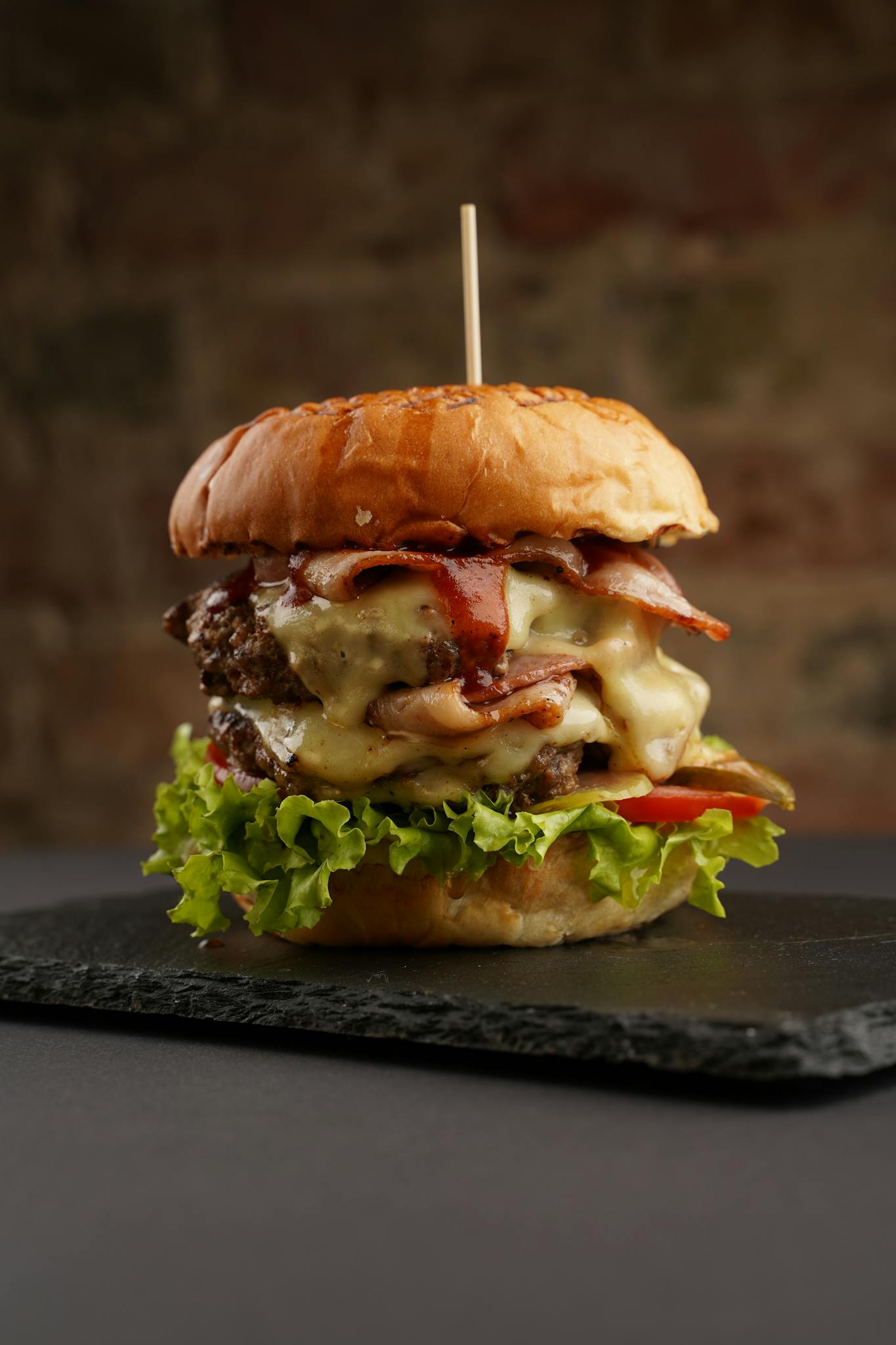 Mouth-watering close-up of a gourmet burger with bacon and cheese, perfect for food lovers.